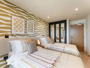 A bedroom with two beds and artwork on the wall at tbc in St. Ives