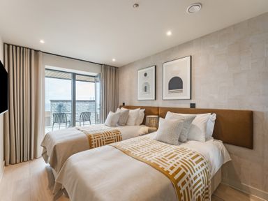 A bedroom with two beds and a sliding door at tbc in St. Ives