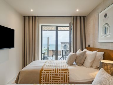 A bedroom with a bed and view of the sea at tbc St. Ives