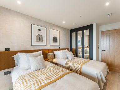 A bedroom with two beds and artwork on the wall at tbc in St. Ives