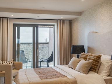 A bedroom with a bed and chairs at tbc in St. Ives