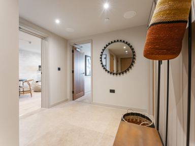 A hallway with a mirror and door at tbc in St. Ives