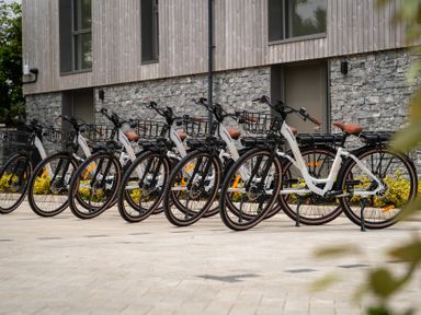 A row of bicycles with baskets outside a building at Hidden 15- Garden Hot Tub in St Ives