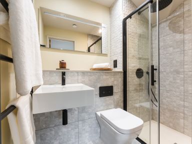A bathroom with a sink, toilet, shower and mirror at tbc in St. Ives