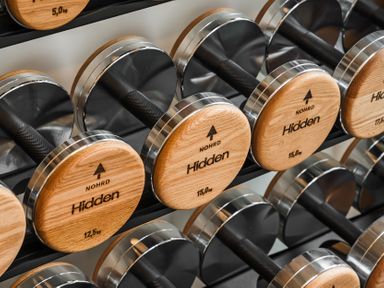 A selection of wooden dumbbells on a rack at Hidden 7- Coastal Loft St Ives