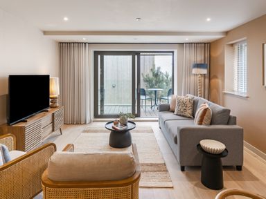 A living room with a television and sliding door to the balcony at tbc St. Ives