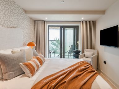 A bedroom with a bed and seating area at tbc in St. Ives