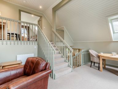 A living room with stairs and furniture at The Derwent Spa (Pet) in Slaley
