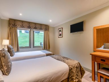 A bedroom with two beds and a television at The Derwent Spa (Pet) Slaley