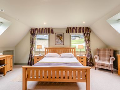 A bedroom with a bed and armchair at The Derwent Spa (Pet) Slaley