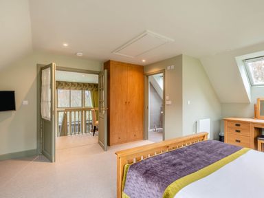 A bedroom with bed, dresser, and wardrobe at The Derwent Spa (Pet) in Slaley