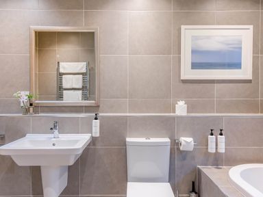 A bathroom with a sink, toilet, mirror, and towel rack at The Derwent Spa (Pet) Slaley