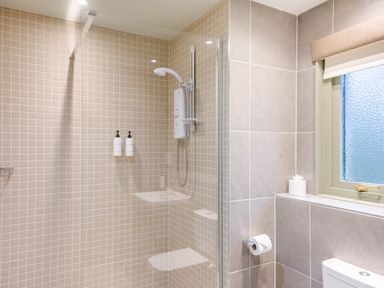 A bathroom with a shower and toiletries at The Derwent Spa (Pet) in Slaley