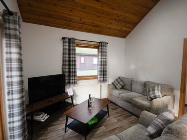 A living room with a sofa and television at Sidlaw in Fowlis near Dundee