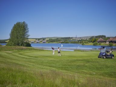 Two golfers on a golf course by a lake at Sidlaw Fowlis near Dundee