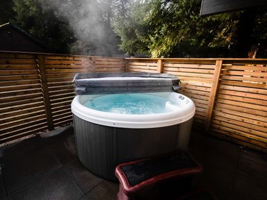 A hot tub with a cover surrounded by a wooden fence at Sidlaw Spa Fowlis near Dundee