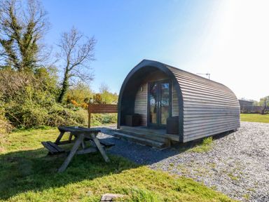 A cabin with picnic table in front at Bron Eifion Pod 1 Criccieth
