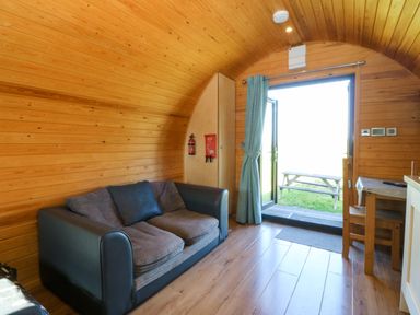 A living room with a sofa and table at Bron Eifion Pod 1 in Criccieth