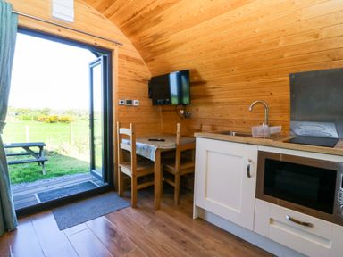 A kitchen with a table and chairs at Bron Eifion Pod 1 Criccieth