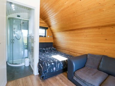 A bedroom with a bed and shower at Bron Eifion Pod 1 Criccieth