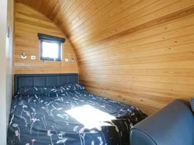 A bedroom with bed and window at Bron Eifion Pod 1 Criccieth