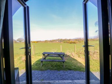 View of a picnic table and a grassy field at Bron Eifion Pod 1 Criccieth