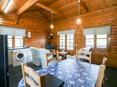 A living room with a table, chairs, and sofa at Lodge 2 - Bron Eifion
