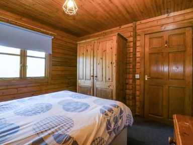 A bedroom with a bed and wardrobe at Lodge 2 - Bron Eifion