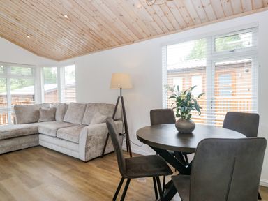 A living room with a sofa and dining table at Fox Red Retreat in Troutbeck Bridge