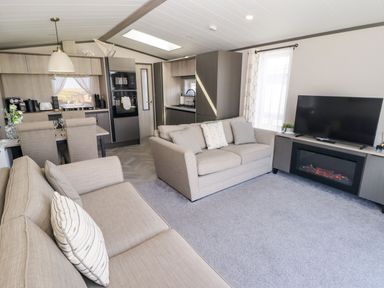 A living room with a sofa and television at Stone Crab Lodge in Haverfordwest