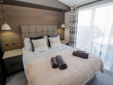 A bedroom with a bed and bedside table at Stone Crab Lodge in Haverfordwest