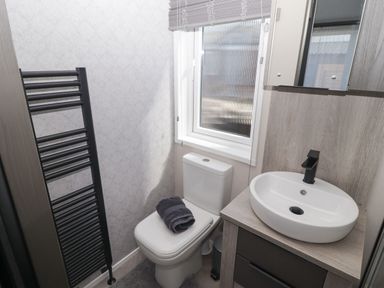A bathroom with a toilet and sink at Stone Crab Lodge in Haverfordwest