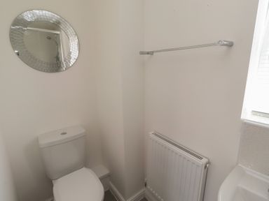 A bathroom with a toilet and a mirror at 26 Field Court