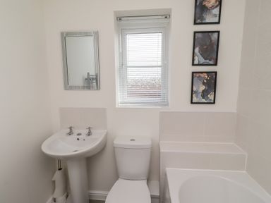 A bathroom with sink, toilet, mirror, and bathtub at 26 Field Court