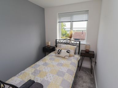 A bedroom with a bed and bedside tables at 26 Field Court