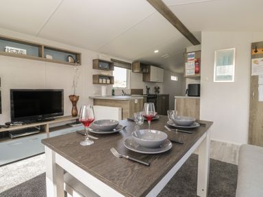A dining area with a table set for meals at Standard Caravan at Three Lochs Holiday Park Newton Stewart
