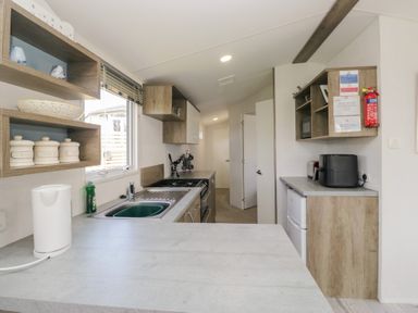 A kitchen with a sink, oven, and refrigerator at Standard Caravan at Three Lochs Holiday Park Newton Stewart