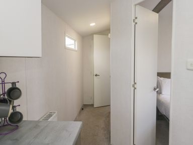 A hallway with doors leading to a bedroom at Standard Caravan at Three Lochs Holiday Park in Newton Stewart