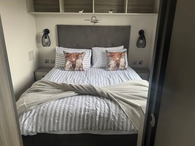 A bedroom with a bed and nightstands at Lochwood Platinum Superior at Three Lochs Holiday Park Newton Stewart