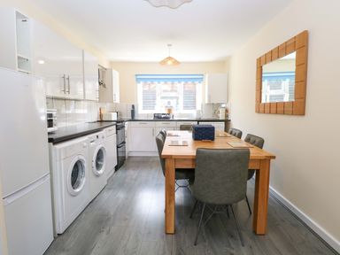 A kitchen with a dining table and appliances at The Mill House Gardens