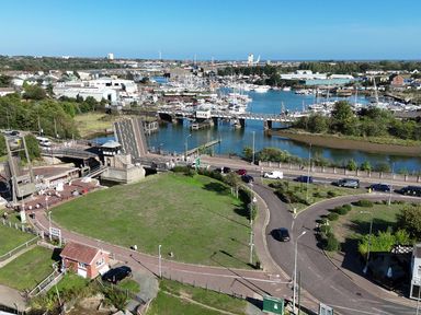 A view of a marina with boats and a river at The Mill House Gardens Oulton Broad