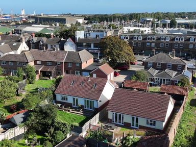 An outdoor view of houses and boats in Oulton Broad at The Mill House Gardens