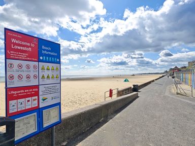 A beach with a sign for information at The Mill House Gardens Oulton Broad