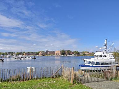 A view of boats on water and buildings in the background at The Mill House Gardens Oulton Broad