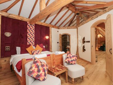 A bedroom with a bed and seating area at Copper Suite in Chulmleigh