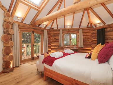 A bedroom with a bed and wooden decor at Copper Suite in Chulmleigh