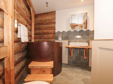 A bathroom with a bath tub and sink at Copper Suite in Chulmleigh