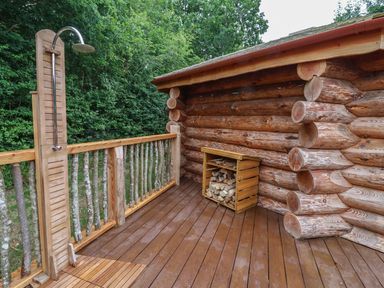 An outdoor shower with wooden decking at Copper Suite in Chulmleigh
