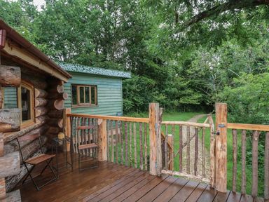 A deck with a wooden railing and chairs at Copper Suite in Chulmleigh
