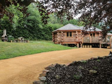 A log cabin with outdoor seating area at Copper Suite in Chulmleigh
